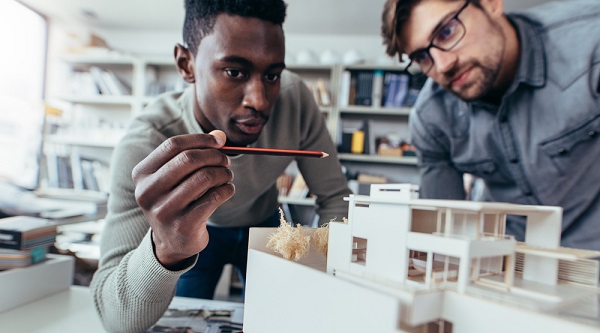 Two people discussing the model of a building