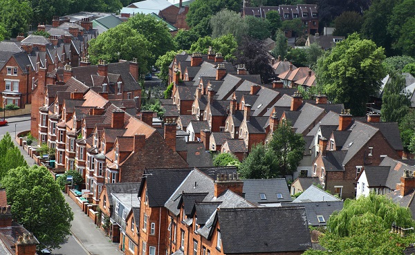 Image of red-brick terraced houses and trees on a street